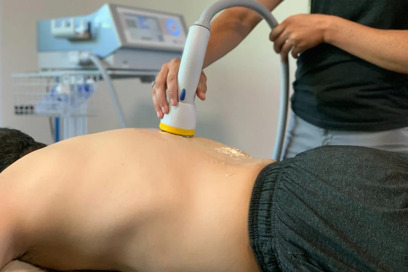 SoftWave therapy applicator being used on a patient's lower back